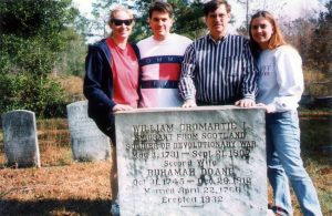 People standing in front of gravestone