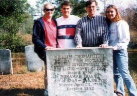 People standing in front of gravestone